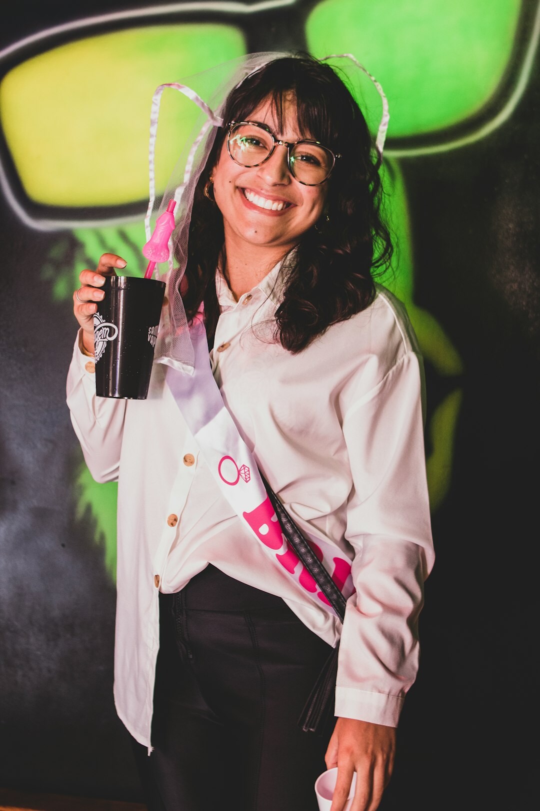 Brazilian mentor with glasses smiling warmly in a studio portrait